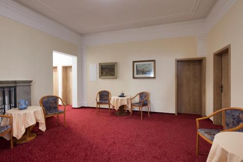 a dining room with two tables and chairs and a table and chairs at Hotel U Černého orla in Telč