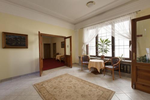 a living room with a table and chairs and a window at Hotel U Černého orla in Telč