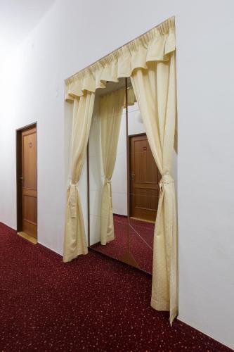 a room with curtains and a red carpet at Hotel U Černého orla in Telč