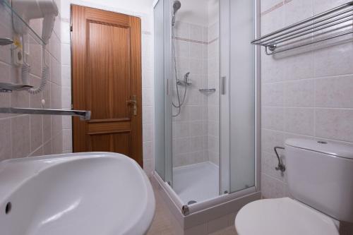 a bathroom with a toilet and a shower and a sink at Hotel U Černého orla in Telč