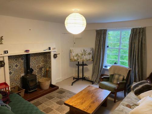 una sala de estar con un sofá y una mesa en Kirkton Cottage whole house in Cairnie Aberdeenshire, en Rothiemay Station