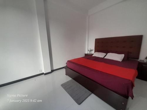 a bedroom with a large bed with a red blanket at Hotel Vista in Kamburugamuwa