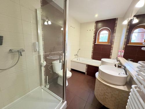 a bathroom with two sinks and a shower and two toilets at Dębowa Dziupla in Białowieża