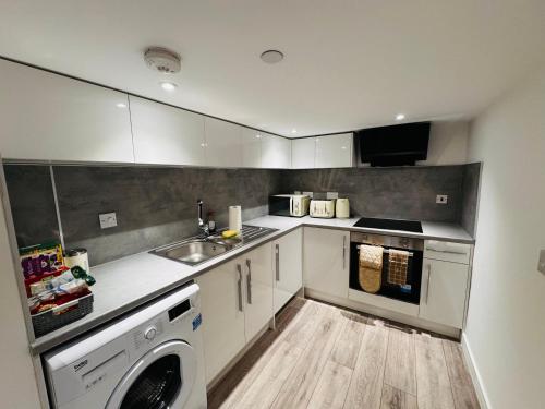 a kitchen with a sink and a washing machine at Ash Residence City Centre in Aberdeen