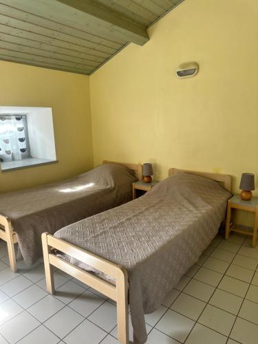 - une chambre avec 2 lits et 2 tables avec des lampes dans l'établissement Auberge Saint Jo, à Saint-Joseph-des-Bancs