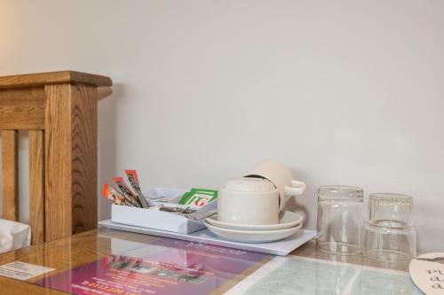 a table with a tray with a cup and other items on it at Ascot Grange Hotel - Voujon Resturant in Leeds
