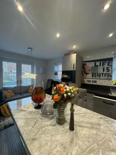 a living room with a table with a vase of flowers at Stunning 3-Bedroom in Alford Lincolnshire in Alford