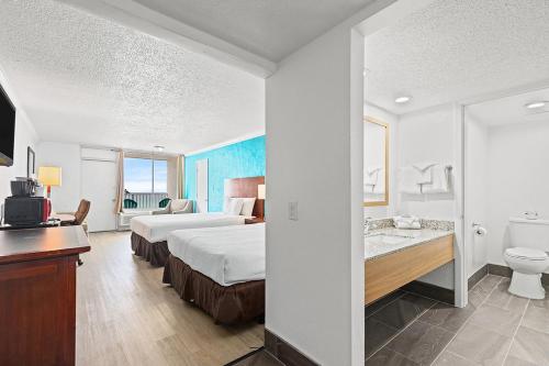 a hotel room with two beds and a bathroom at The Reef At Seahaven Beach Resorts in Panama City Beach