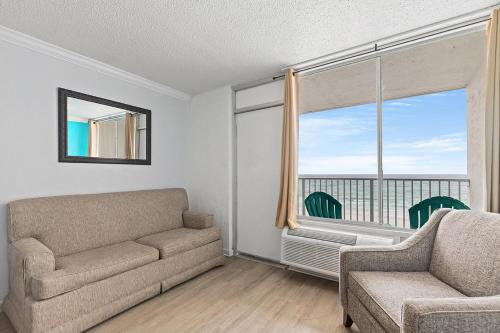 a living room with a couch and a chair and a window at The Reef At Seahaven Beach Resorts in Panama City Beach