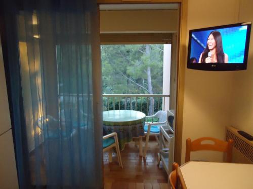 un salon avec une télévision à écran plat au mur dans l'établissement vacances au bord de mer, à Sanary-sur-Mer