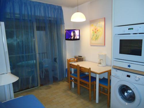 une cuisine avec une table et une machine à laver dans l'établissement vacances au bord de mer, à Sanary-sur-Mer