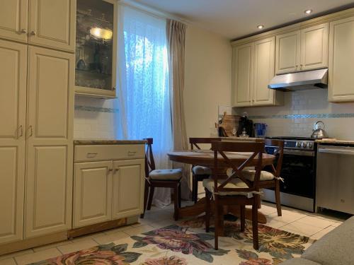 a kitchen with white cabinets and a table and chairs at NYC Apartment by the Harbor in Saint George