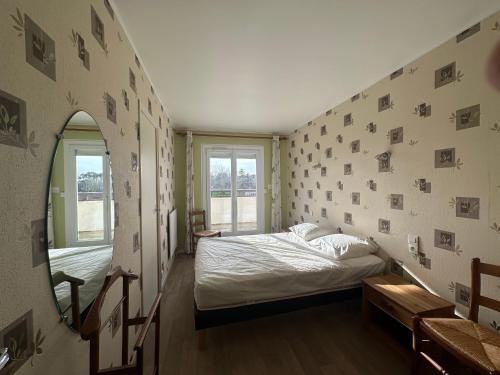 - une chambre avec un lit et un mur avec des photos dans l'établissement Appartement 3 pièces à Cabourg, 300m de la plage, 6 pers, balcons, parking, animaux acceptés - FR-1-487-296, à Cabourg