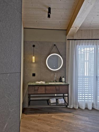 a bathroom with a sink and a mirror at Hotel Mürren Palace in Mürren