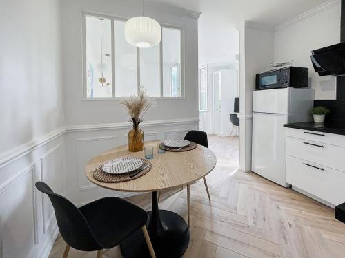 une cuisine avec une table et des chaises dans une pièce dans l'établissement L'Écrin Dieppois - Proche Plage & Parking Gratuit, à Dieppe