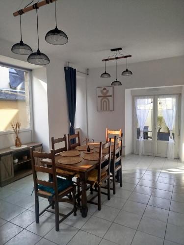 une salle à manger avec une table et des chaises en bois dans l'établissement Au refuge de la baie, à Pontorson