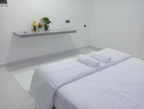a white bed with two white pillows on it at Secret Escape in Fuvahmulah