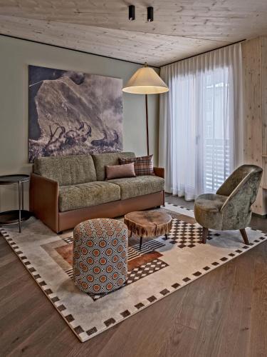 a living room with a couch and a chair at Hotel Mürren Palace in Mürren