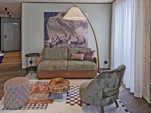 a living room with a couch and a chair at Hotel Mürren Palace in Mürren