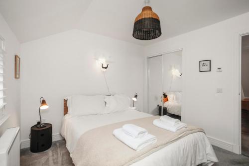 a white bedroom with two towels on a bed at 27 Strathtay Lodges in Aberfeldy