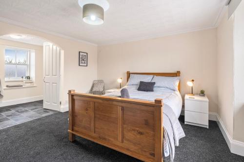 a bedroom with a bed with a wooden bed frame at Keith - Spacious 4 bed house in Keith