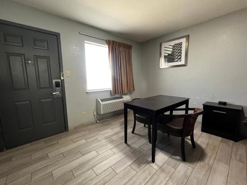 Zimmer mit einem Tisch, einer Tür und einem Fenster in der Unterkunft Budget Inn Motel in San Antonio