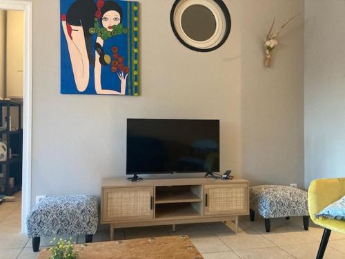 un salon avec une télévision à écran plat sur un mur dans l'établissement Très Bel appartement, à Villers-Outréaux
