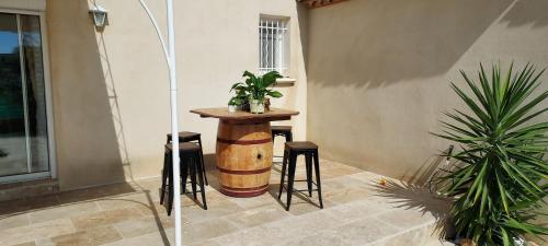 une petite table avec tabourets à côté d'un bâtiment dans l'établissement villa petite camargue, à Aigues-Mortes