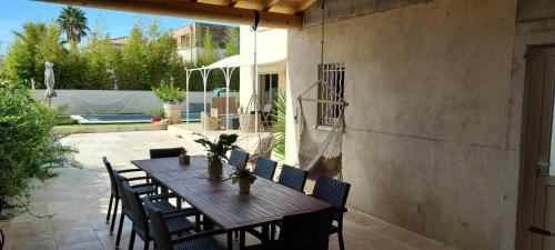 une table et des chaises en bois sur une terrasse dans l'établissement villa petite camargue, à Aigues-Mortes