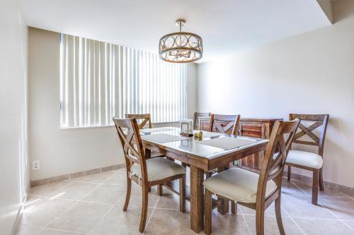 a dining room with a wooden table and chairs at Comfortable Jensen Beach Condo with Pool View! in Jensen Beach