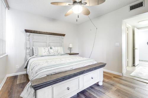 a bedroom with a white bed and a ceiling fan at Comfortable Jensen Beach Condo with Pool View! in Jensen Beach