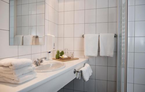 a bathroom with a sink and a mirror and towels at 22 Hill Hotel in Reykjavík