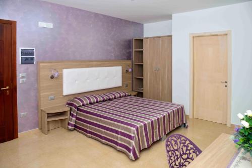 a bedroom with a bed with a striped blanket at Spazi Preziosi in Torre San Giovanni Ugento