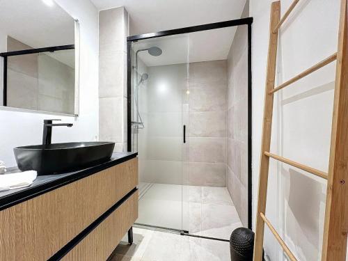 une salle de bain avec un lavabo et une douche en verre dans l'établissement Cosy T2 à proximité de la Gare 15 minutes de Lille, à Armentières