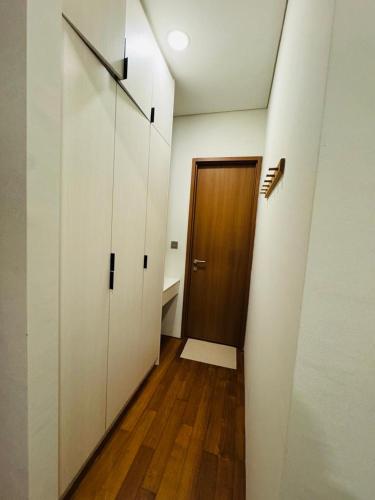 a hallway with a door and a wooden floor at URBAN COMFY HOME at SkySuites Near KLCC Complimentary Breakfast in Kuala Lumpur