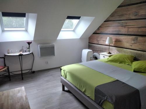 une chambre avec un lit et une table et deux fenêtres dans l'établissement Le morvan de serge, à Saint-Brancher