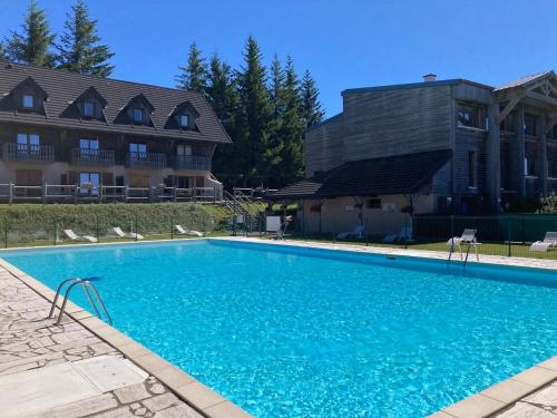 une grande piscine bleue devant un immeuble dans l'établissement Appartement duplex 8 pers à Super-Besse avec wifi et piscine chauffée, à Besse-et-Saint-Anastaise