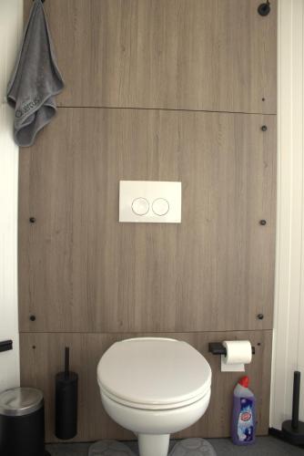 a white toilet in a bathroom with wooden walls at The waterfront & birds nest in Evergem