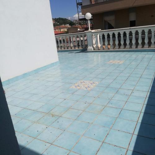 a balcony with a blue tile floor and a white railing at Donato C alloggio estivo in Scauri