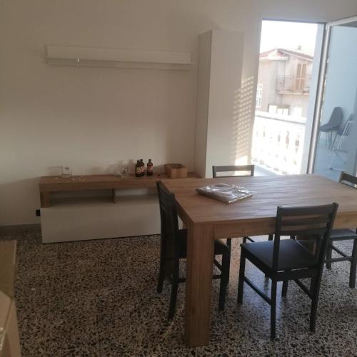 a dining room with a wooden table and chairs at Donato C alloggio estivo in Scauri