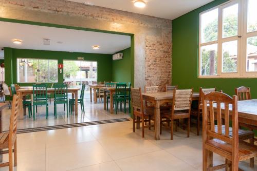 a dining room with green walls and wooden tables and chairs at The Garden in Bonito