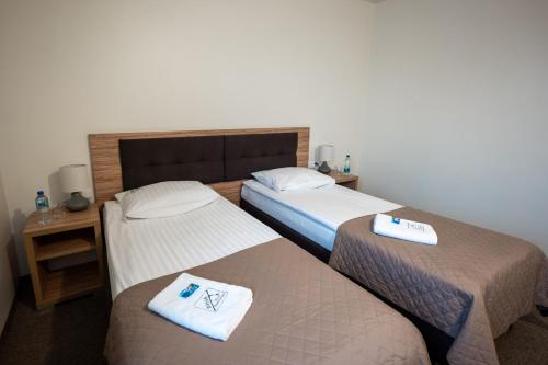 two beds in a hotel room with towels on them at Hotel Bosak in Szczecin