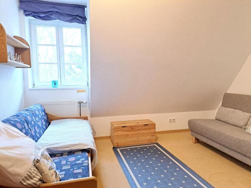 a small living room with a couch and a chair at Achtern Diek Haus 12d Wohnung 6 in Müggenburg