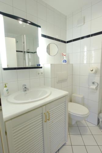 a white bathroom with a sink and a toilet at Achtern Diek Haus 13d Wohnung 6 in Müggenburg