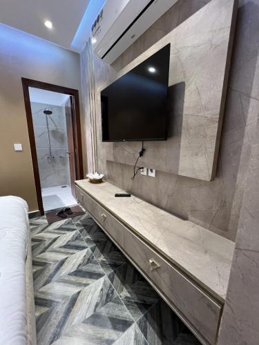 a room with a television on a wall with a bed at Courteous Hotel in Islamabad