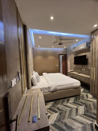 a bedroom with a large bed and a tv at Courteous Hotel in Islamabad
