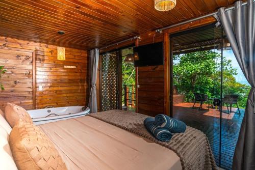 a bedroom with a bed and a tub and a window at Nosso Mar in Florianópolis