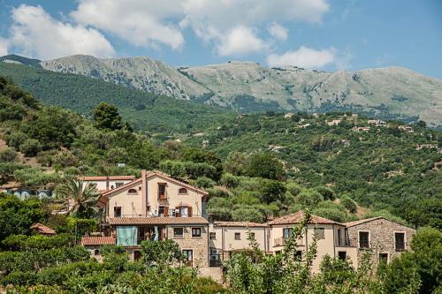a group of buildings in front of a mountain at Azienda Agrituristica Bergi in Castelbuono