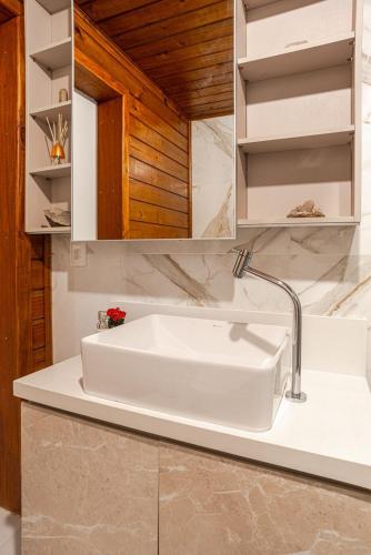 a bathroom with a white sink and a mirror at Nosso Mar in Florianópolis