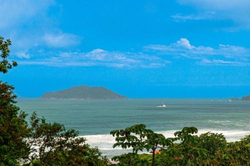 a view of a beach with a boat in the water at Nosso Mar in Florianópolis